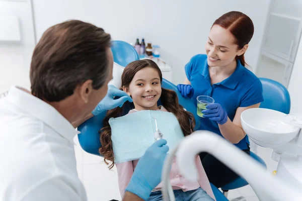 Kleine positieve jongen met krullend haar lacht om haar arts — Stockfoto