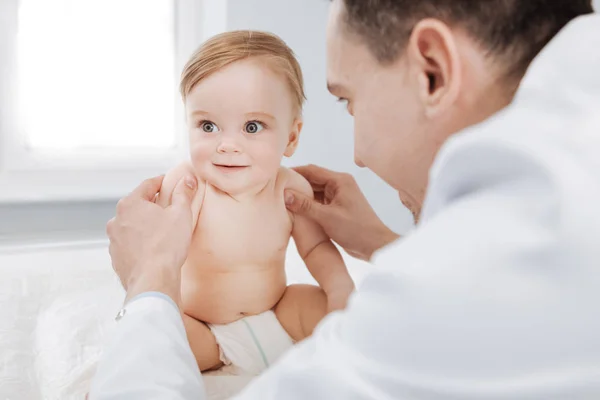 Increíble pediatra profesional entreteniendo a su lindo paciente —  Fotos de Stock