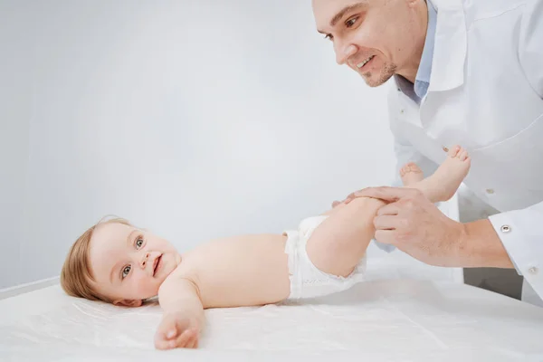 Pediatra proficiente treinado fazendo exercícios com seu pequeno paciente — Fotografia de Stock