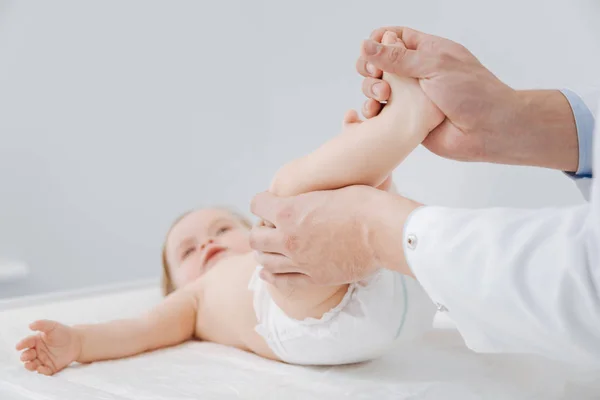 Ügyes szakmai gyermekorvos kisgyermekek ízületek ellenőrzése — Stock Fotó