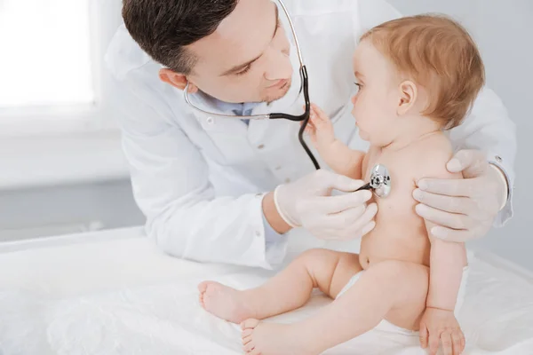 Kíváncsi, élénk kisgyermek látszólag érdekelt orvosok berendezések — Stock Fotó