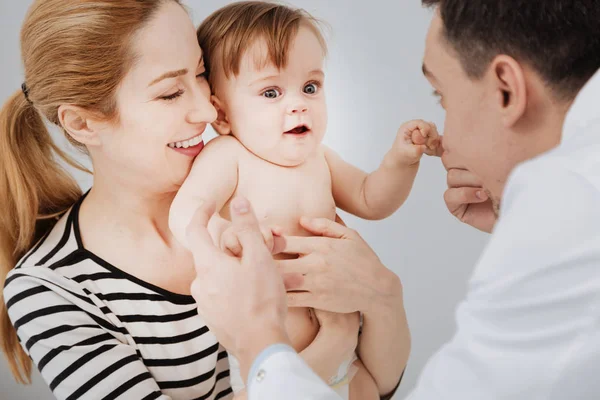 Positive dedicated pediatrician preparing kid for examination — Stock Photo, Image