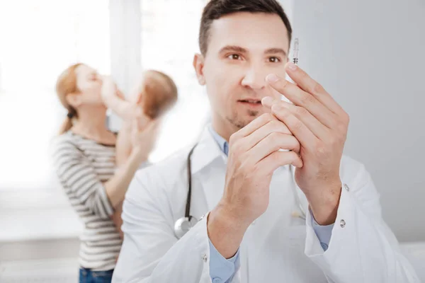 Focused scrupulous pediatrician preparing an injection — Stock Photo, Image