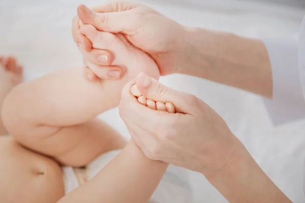 Easy mindful pediatrician massaging childs tiny feet — Stock Photo, Image