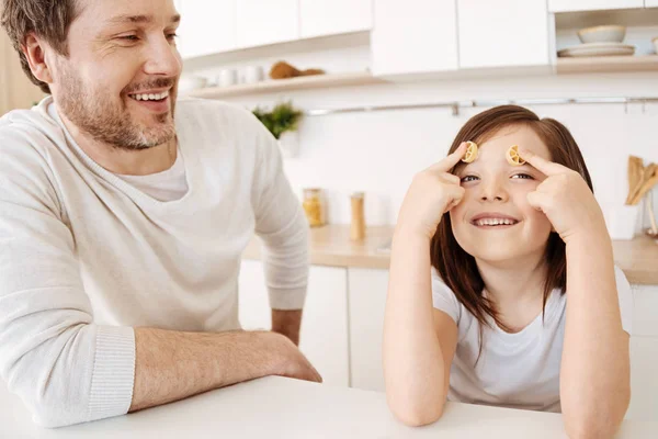 Girl pressing two pieces of rotelle pasta to her forehead — Stock Photo, Image