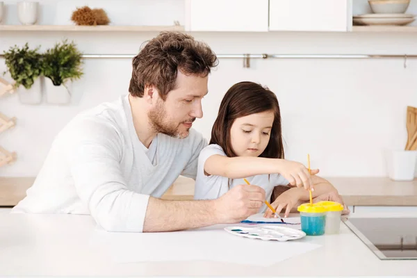 Father and his daughter engaged in the painting process — Stock Photo, Image