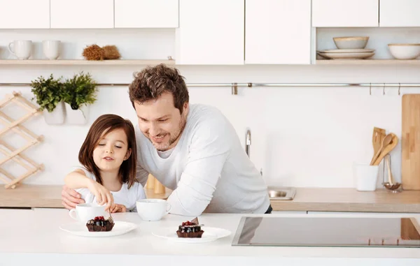 Vater sieht zu, wie sich seine Tochter Kuchen gönnt — Stockfoto