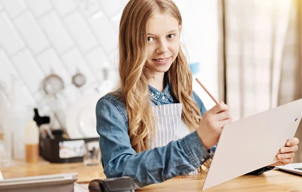 Charmante tienermeisje maken van aantekeningen in een menu — Stockfoto