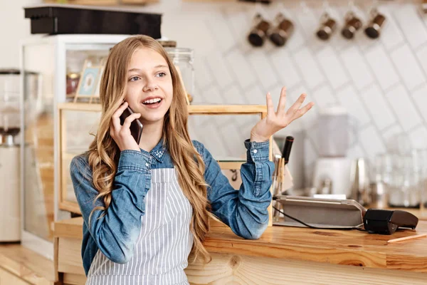 Αρκετά εφηβικό κορίτσι μιλάει στο τηλέφωνο στη δουλειά — Φωτογραφία Αρχείου