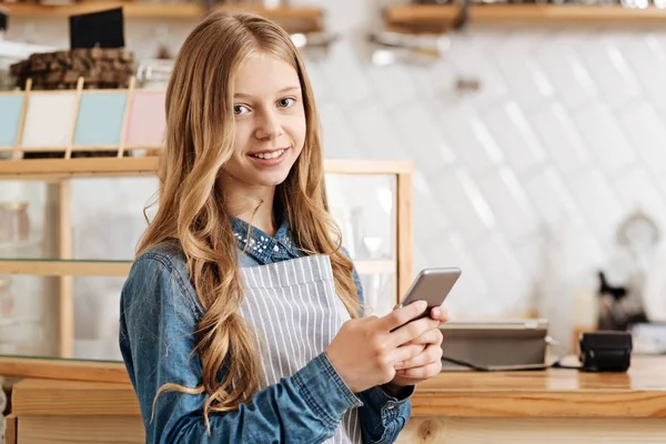 Gyönyörű tizenéves barista pózol a mobilra — Stock Fotó