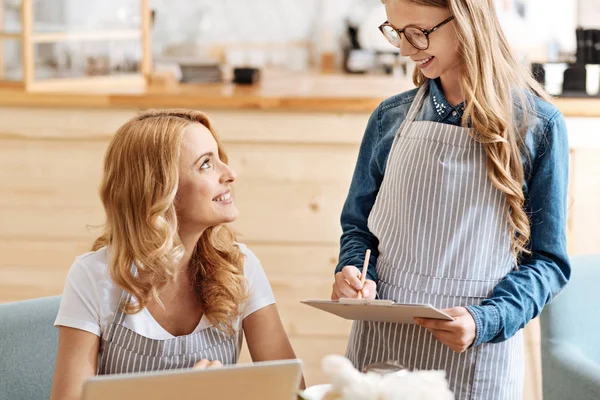 Hija adolescente consultando a su madre sobre un menú —  Fotos de Stock