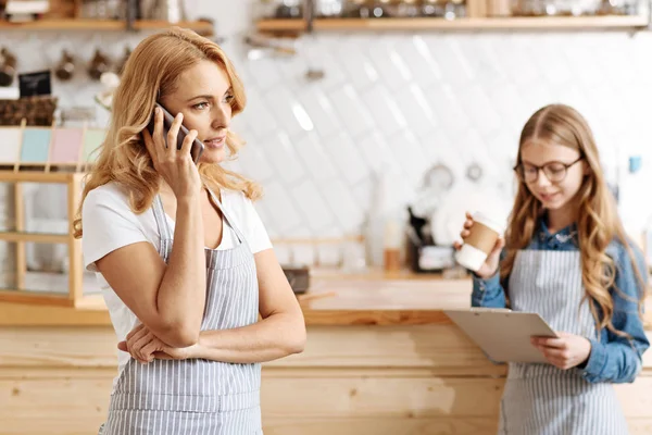 Hermoso propietario de café hablando por teléfono con los socios — Foto de Stock