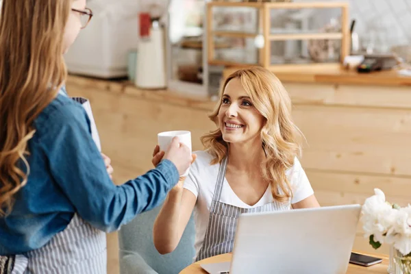 Hija cariñosa tratando a su madre con una taza de café — Foto de Stock