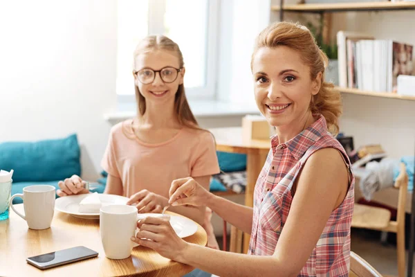 Mor och dotter limning samtidigt äta ute — Stockfoto