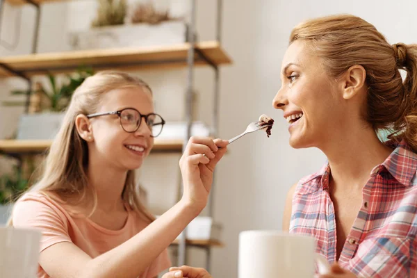 Hija cariñosa alimentando el pastel a su madre —  Fotos de Stock