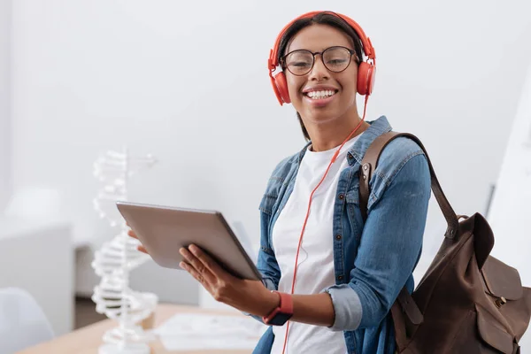 Glad glad student som använder tekniska enheter — Stockfoto