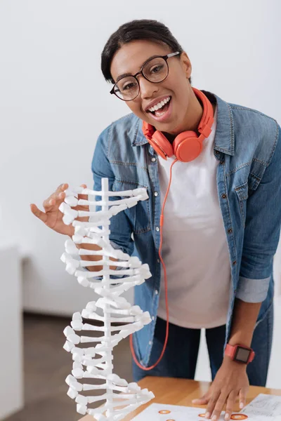 Estudiante alegre y agradable de pie cerca del modelo genético — Foto de Stock