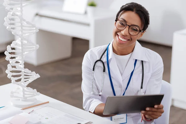 Médico experiente alegre usando um comprimido — Fotografia de Stock