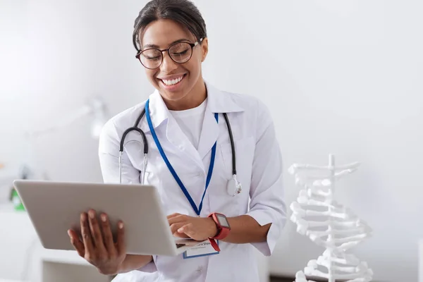 Mujer alegre positiva mirando la pantalla del ordenador portátil — Foto de Stock