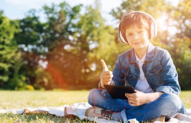 Onun tableti pikniğinde kullanarak çekici olumlu çocuk