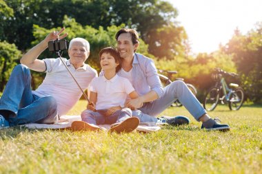 Bir resim için Smartphone kullanarak anlayışlı meraklı çocuk