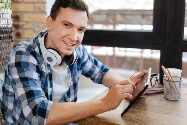 Simpático cara alegre brincando com seu gadget — Fotografia de Stock