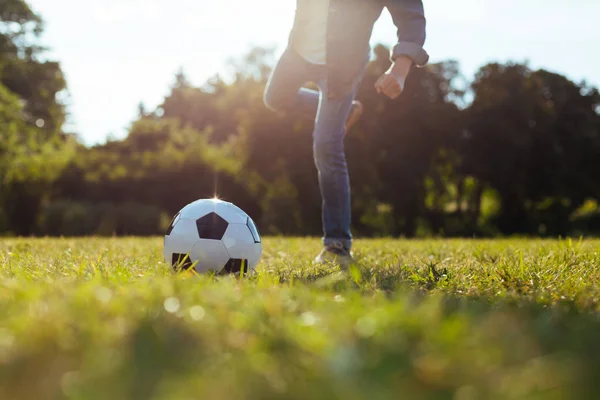 Garoto enérgico positivo jogando futebol — Fotografia de Stock