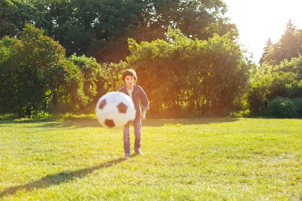 Opgewonden knappe jongen beheersen zijn voetbal vaardigheden — Stockfoto