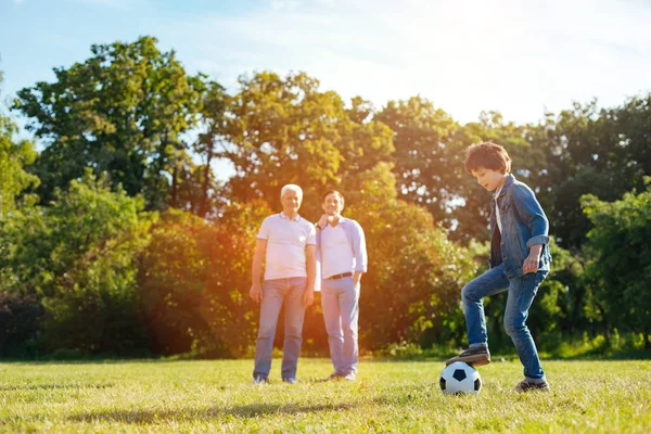 Äldre man och hans son titta på ungen spelar — Stockfoto