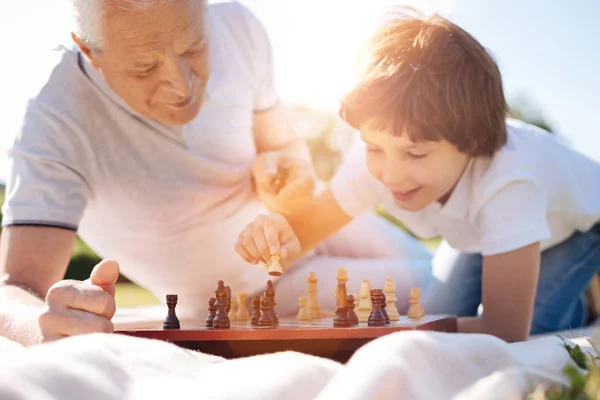 Un uomo saggio e simpatico che incoraggia suo nipote a giocare a scacchi — Foto Stock