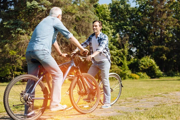 Fröhlicher ungezwungener Mann und sein Sohn treffen sich zum Ausritt — Stockfoto