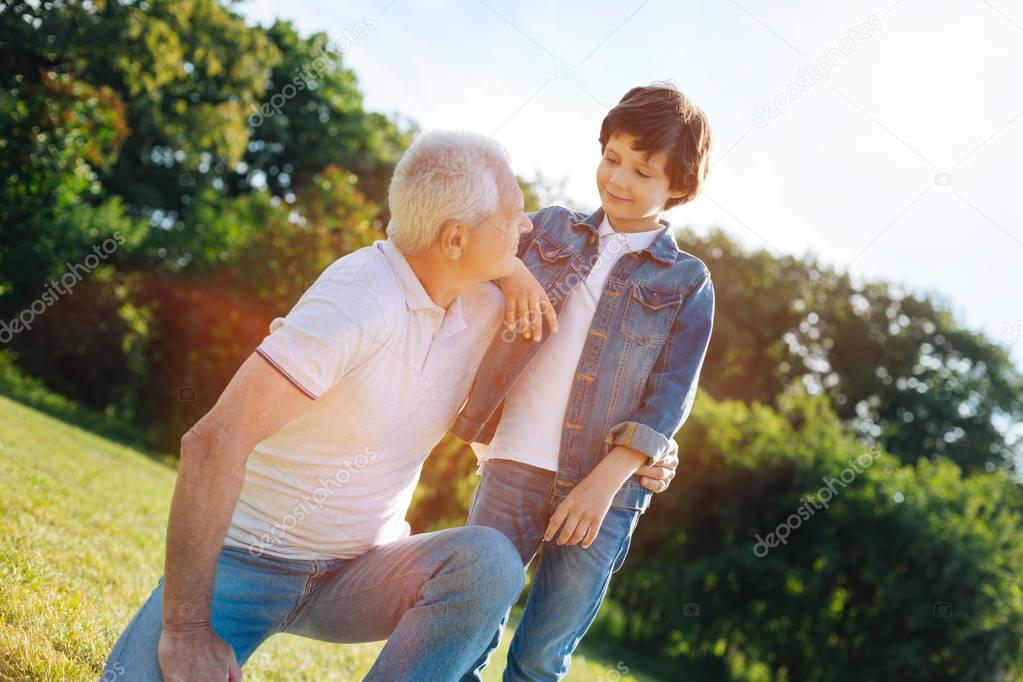 Charming wise man talking to his grandson