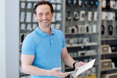 Akıllı telefon tutarak ve kameraya gülümseyen parlak shopper