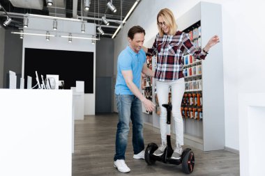 Heyecanlı genç kadın üzerinde Mini segway araba kullanmayı öğrenme