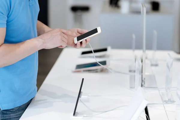 Närbild av man kontrollera telefon på display i butiken — Stockfoto