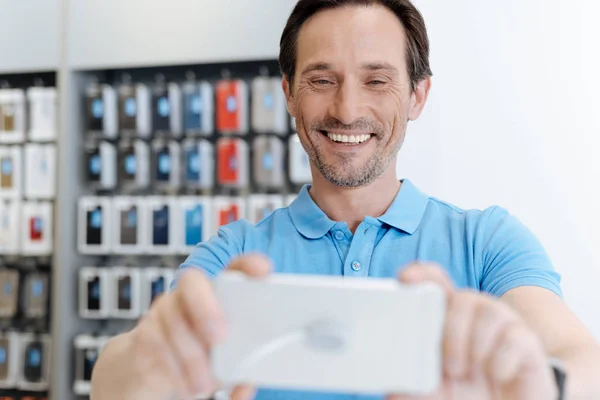 Сияющий взрослый покупатель делает селфи с шаблоном смартфона — стоковое фото