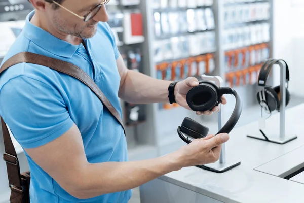 Primer plano del hombre mirando auriculares profesionales — Foto de Stock