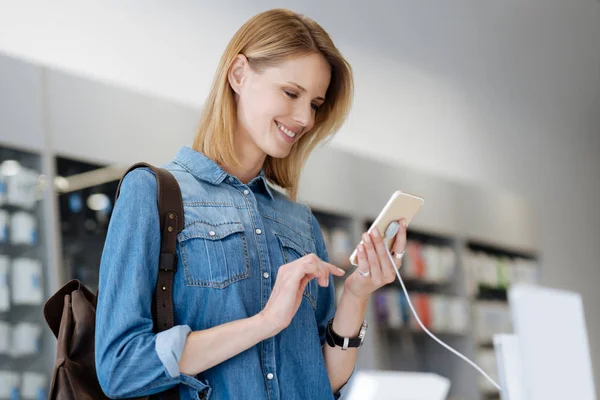 Vrouw stralend tijdens het gebruik van de sjabloon mobiele telefoon — Stockfoto