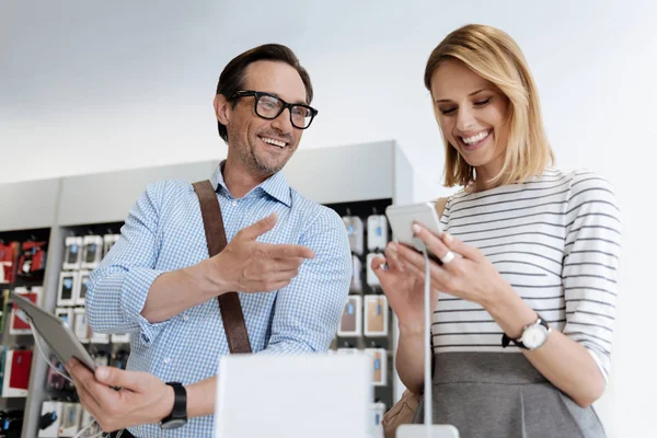 Clientes radiantes falando sobre gadgets na loja — Fotografia de Stock