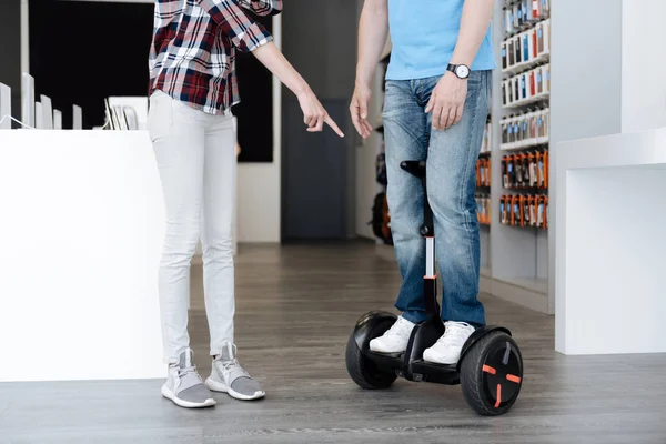 Az eladó segít a vevő a hoverboard közelről — Stock Fotó