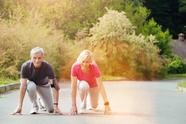 Positivo casal ativo se preparando para correr — Fotografia de Stock