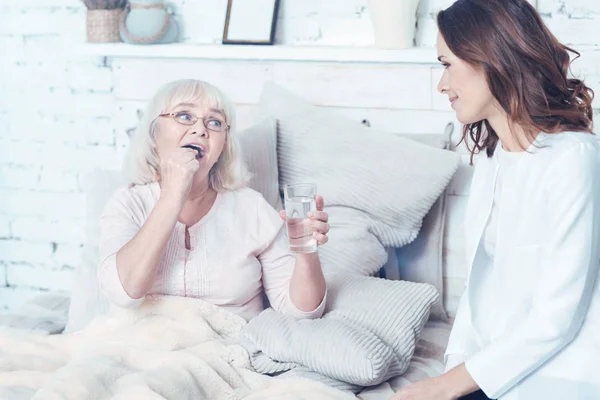 Відповідальна медсестра піклується про старіння пацієнта вдома — стокове фото