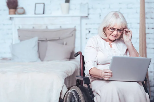 Mujer con discapacidad de edad utilizando gadget en casa — Foto de Stock