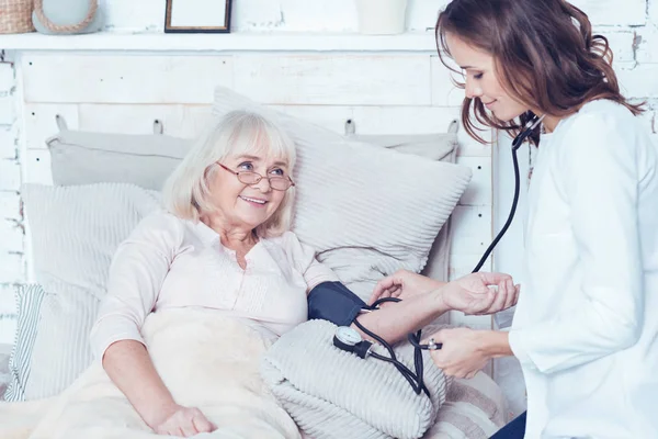Уважний доглядач вимірювання пенсійного кров'яного тиску в домашніх умовах — стокове фото