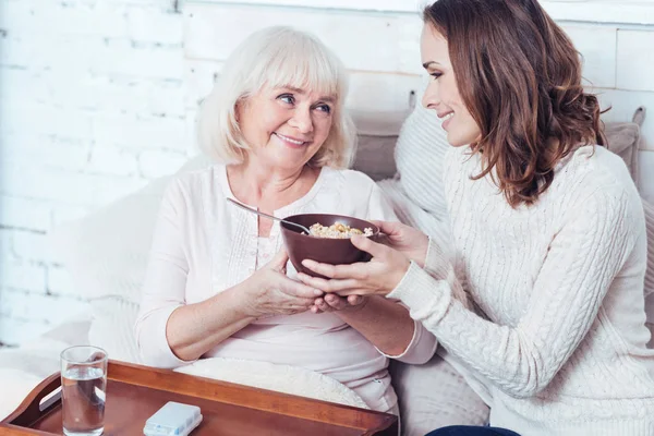 Gelukkig kleindochter genieten van ontbijt met voormalig grootmoeder thuis — Stockfoto