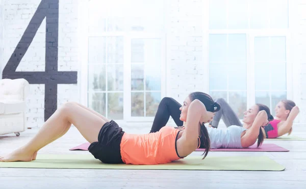 Unga damer gör abs på gym — Stockfoto