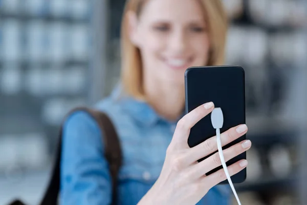 Lächelnde blonde Frau macht Selfie mit Smartphone-Attrappe — Stockfoto