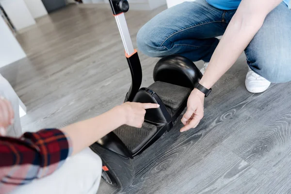 Close up of salesman assisting female customer with segway mini — Stock Photo, Image