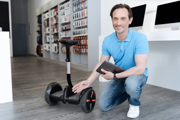 Verkäufer posiert mit Tablet und Mini-Segway für Kamera — Stockfoto