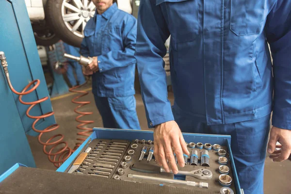 Scrupulous top mechanic employing professional equipment — Stock Photo, Image